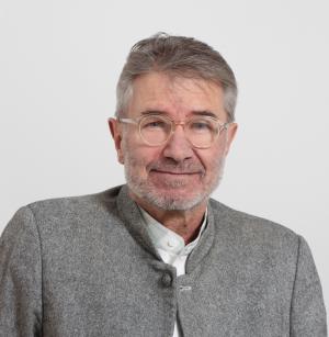 Porträt eines älteren Mannes mit Brille und grauem Janker