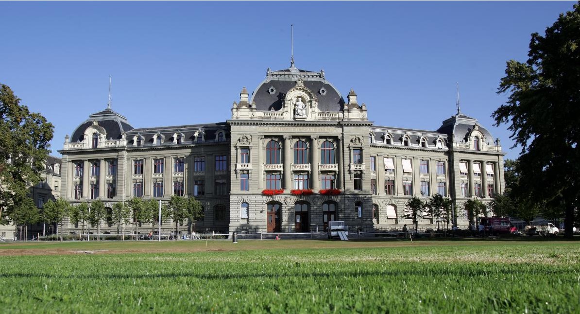 Vue générale du bâtiment principal avec pelouse au premier plan en été © Université de Berne